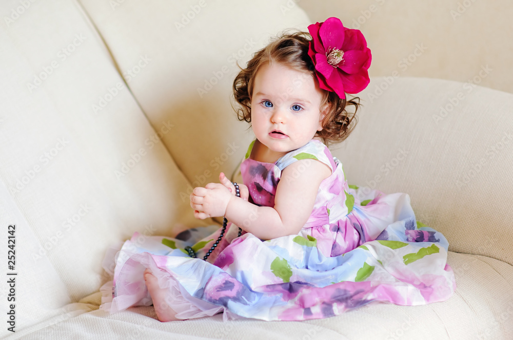 Cute baby-girl with flower on her hair try on necklaces Cute baby-girl with flower on her hair try on necklaces