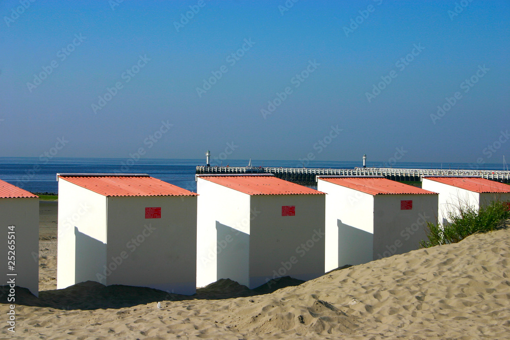 Close Up Beach Cabines with pier in background Close Up Beach Cabines with pier in background