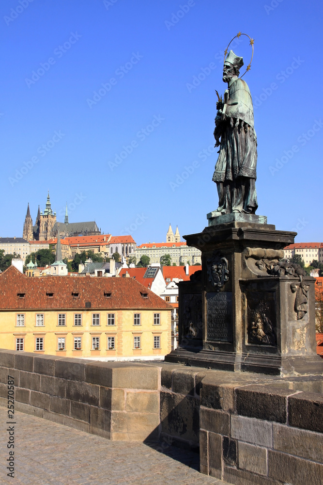 Statue on the Charles Bridge with Prague Castle