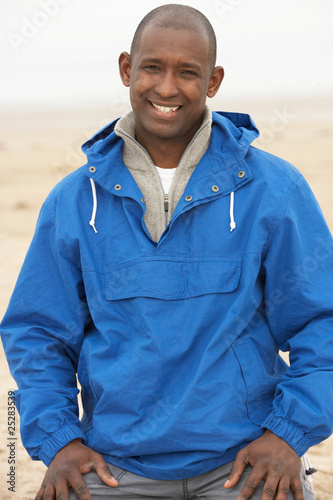 Man Relaxing On Beach In Autumn Clothing