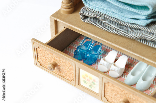 A collection of doll shoes in a drawer. Focus on the blue shoes. photo