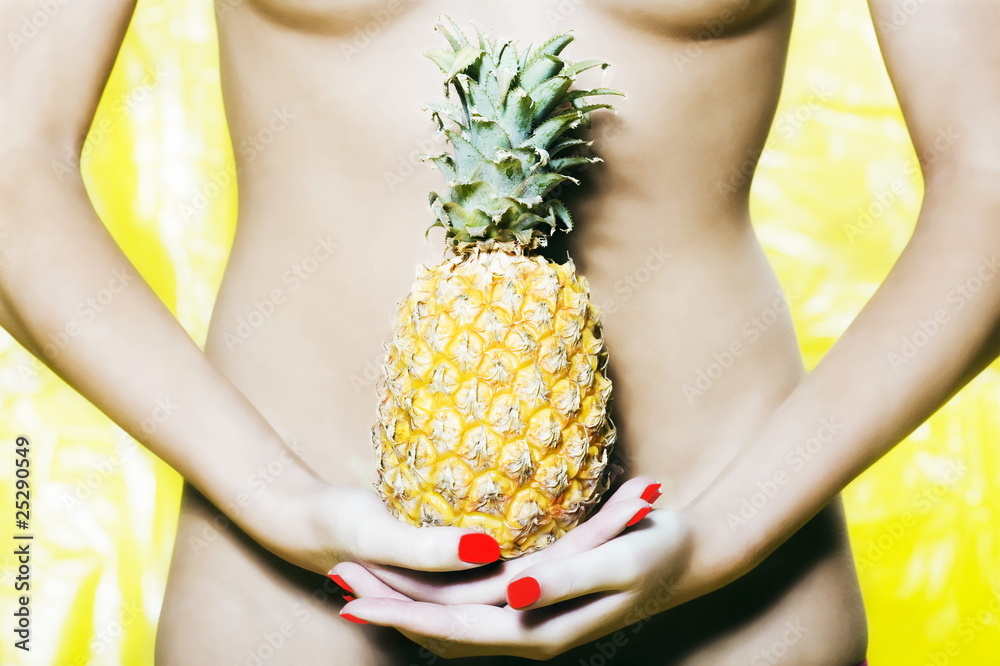 Obraz premium Woman Abdomen holding a pineapple