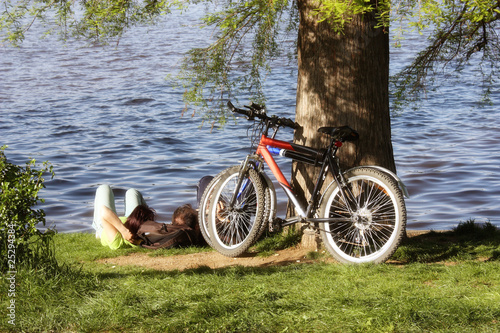 Valokuva Couple relaxing in the park with parked bicycle