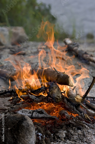 Photo of a campfire on the rocky shore of the lake