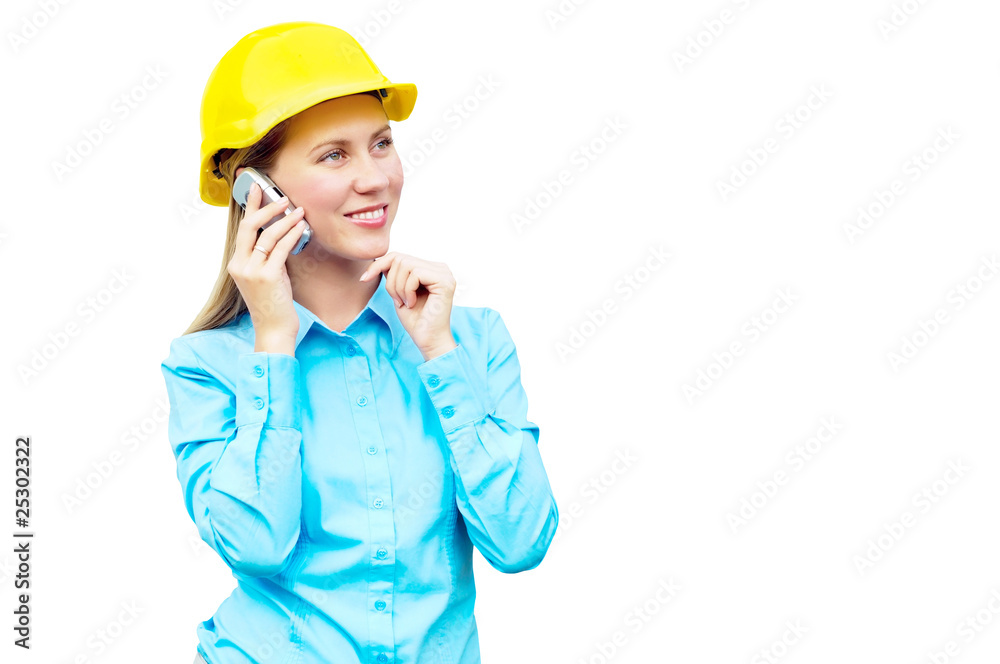 Young architect-woman wearing a protective helmet standing on th Young architect-woman wearing a protective helmet standing on th