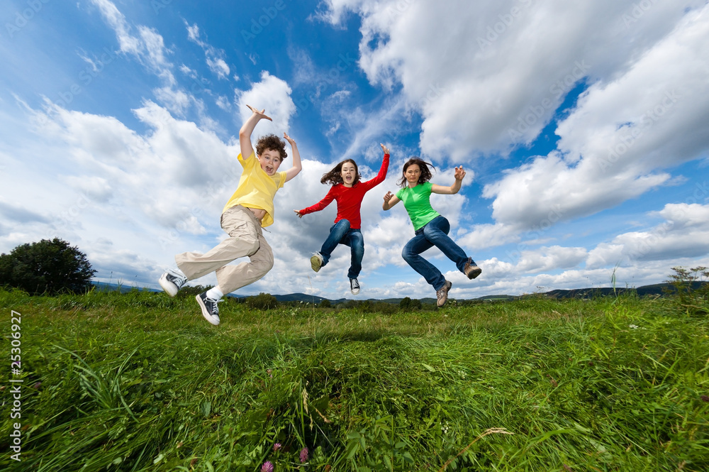 Active family - mother and kids jumping outdoor Active family - mother and kids jumping outdoor