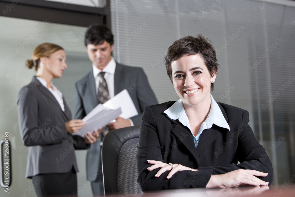 Three office workers meeting in boardroom Three office workers meeting in boardroom