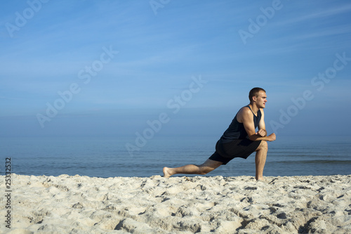 Młody mężczyzna gimnastykujący się na plaży
