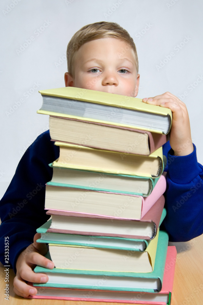 young boy looking out of top of books young boy looking out of top of books
