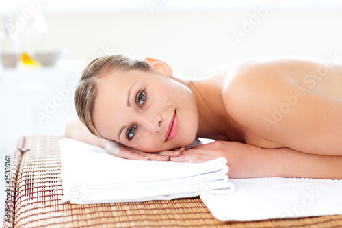 Close-up of a cute woman lying on a massage table with a flower