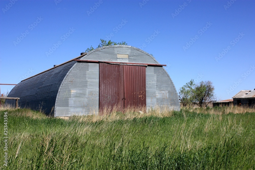 An old ranch with a metal building no longer used.