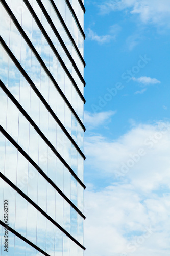 Glass building wall with reflection of clouds