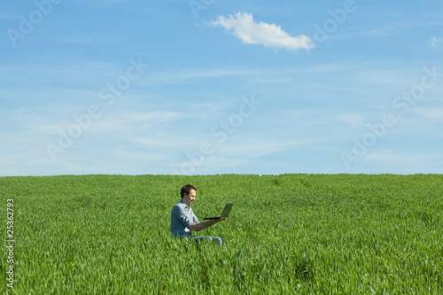 young man using laptop in the field © Evgeniya Uvarova
