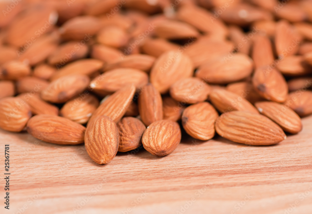 Almonds spread on a wooden table top Almonds spread on a wooden table top