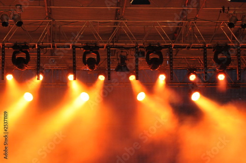 Spotlights illuminating the stage - yellow lightbeams photo