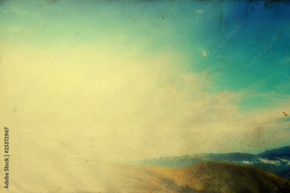 Cloudy blue sky upon green mountain ridge