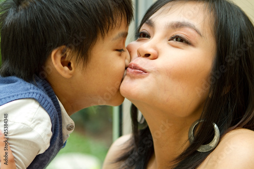 Asian boy and mother kissing