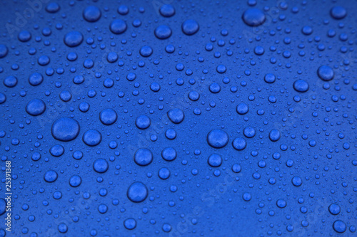 rain drops on a blue car body, shallow focus