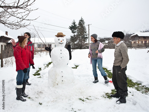 Happy family around a snowman