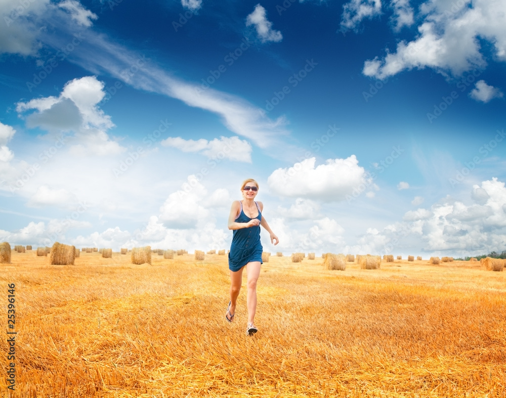 Woman Running Through Summer Harvested Field