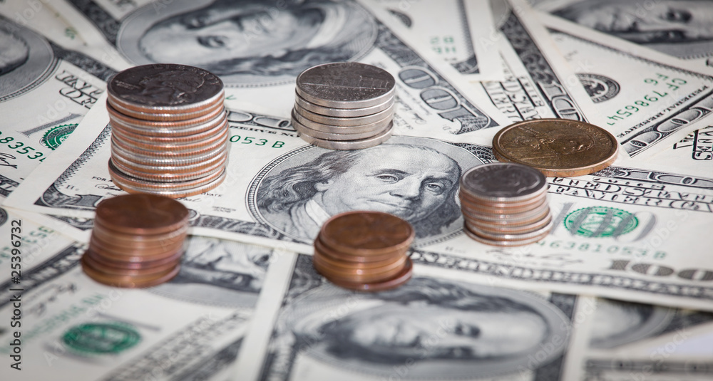 Fototapeta premium coins over hundred dollar bills background close up view