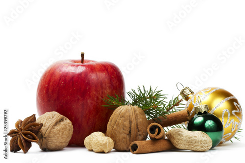 apfel, nüsse, zimtstangen, anis und christkugeln mit zweig