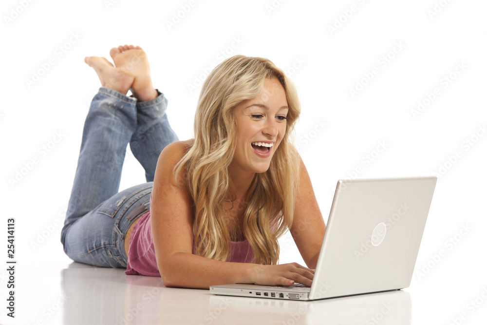 Casual young girl with jeans laying on floor with laptop