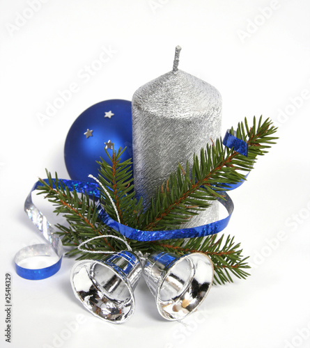 Silver candle with the twig of the spruce and bells