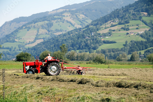 Tractor plowing in front of mountains in austrian farm