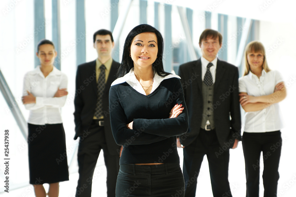 Five young business persons are standing as a team Five young business persons are standing as a team