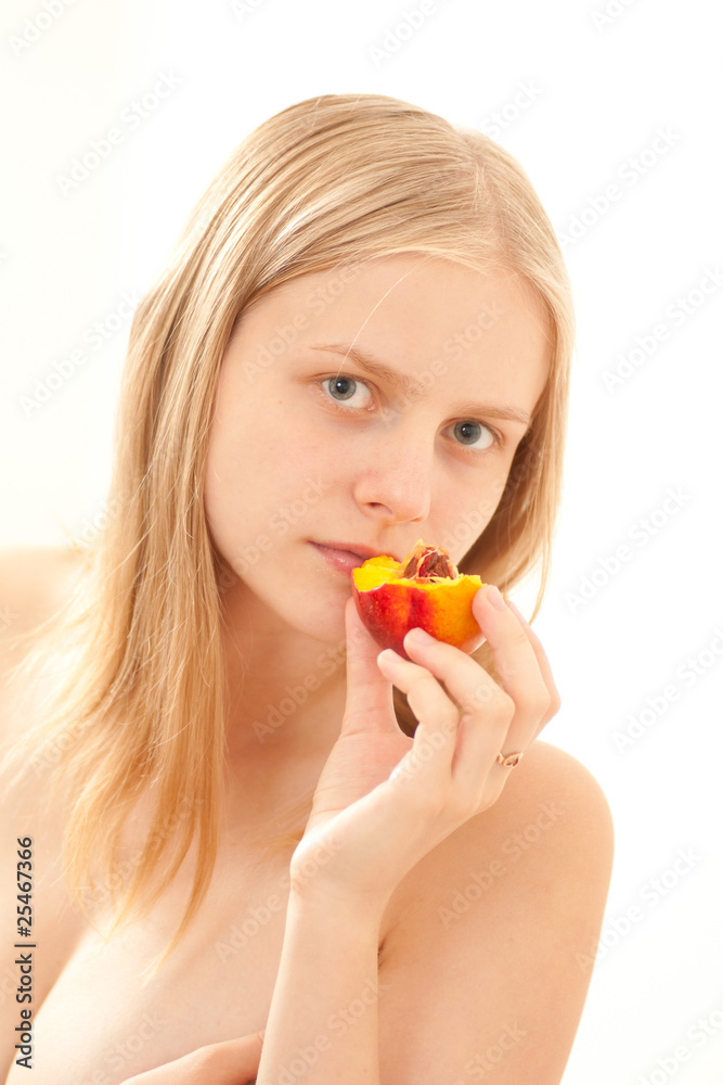 Beautiful young girl eating a peach on white Beautiful young girl eating a peach on white