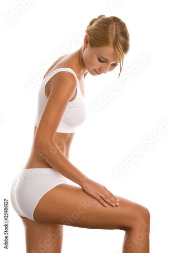 Young woman massaging her leg