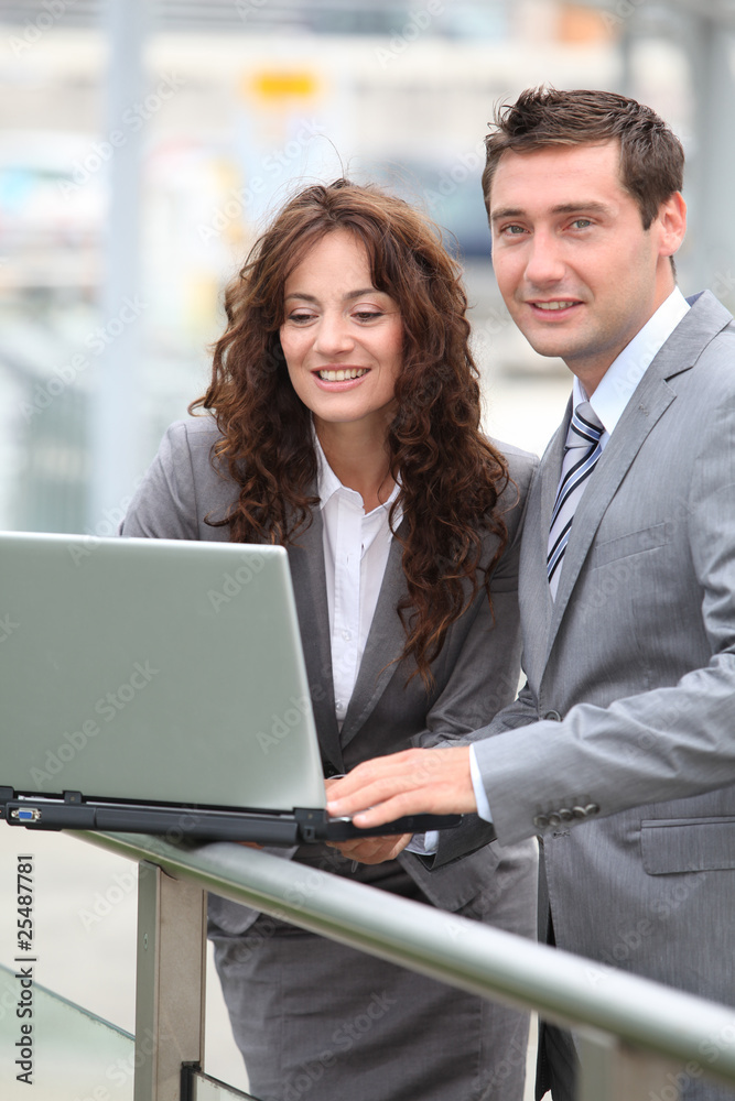 Business people working on laptop computer outside Business people working on laptop computer outside