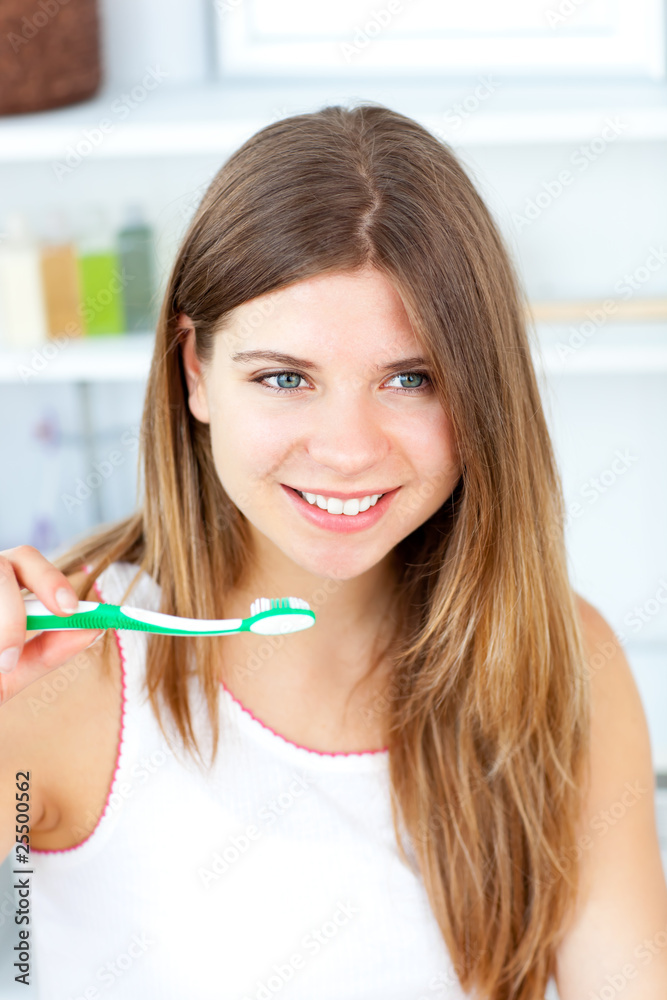 Blissful caucasian woman holding a toothbrush in the bathroom Blissful caucasian woman holding a toothbrush in the bathroom