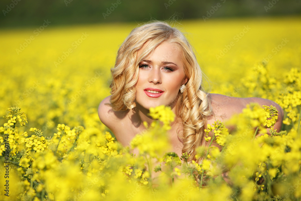 Beautiful young blonde woman in a field of wildflowers.