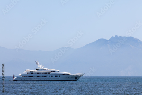 Cruising yacht in the sea on the background of mountains © Anton Balazh