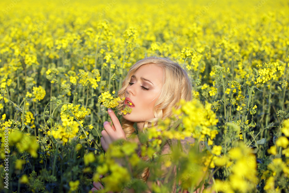 Beautiful young blonde woman in a field of wildflowers.