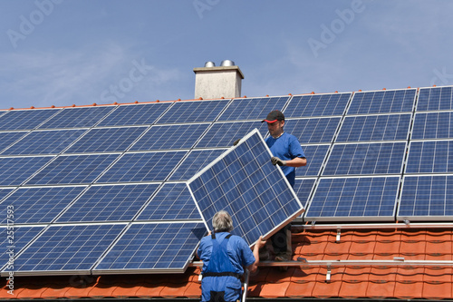 Two workmen are mounting solar photo