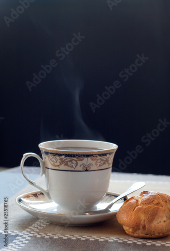 A cup of hot coffee with eclair