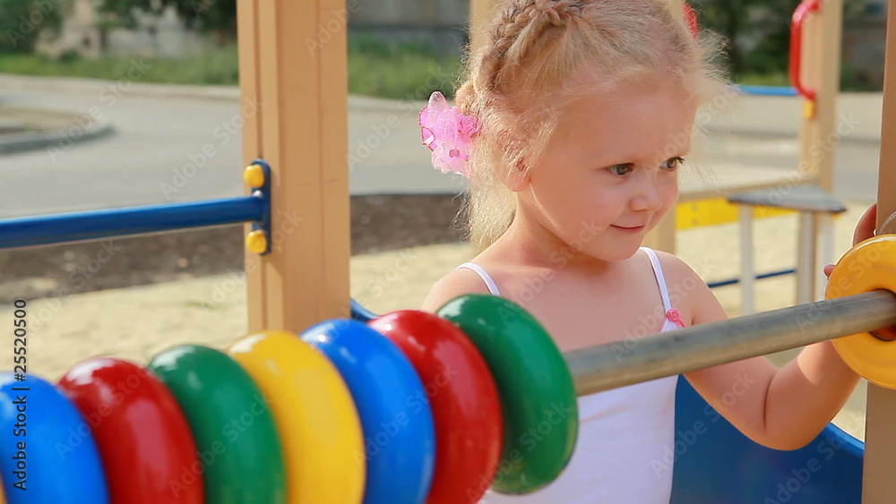 Little girl counting with abacus on playground