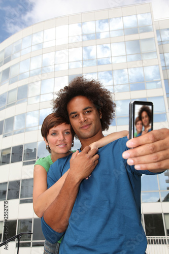 Young couple taking picture of itself with mobile phone