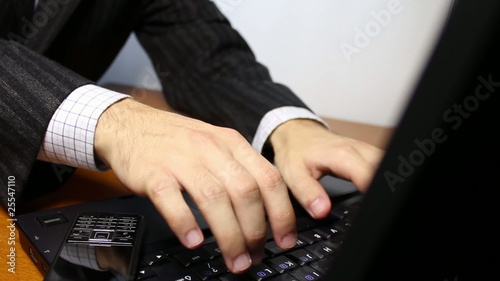 Businessman typing on laptop keyboard
