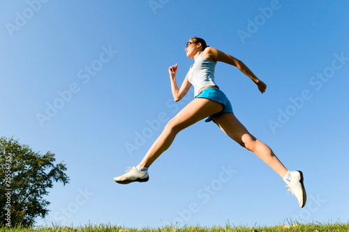 young woman running on the grass