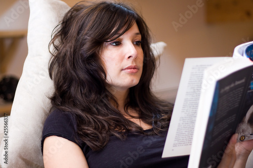 beautiful woman reading a book on the couch photo