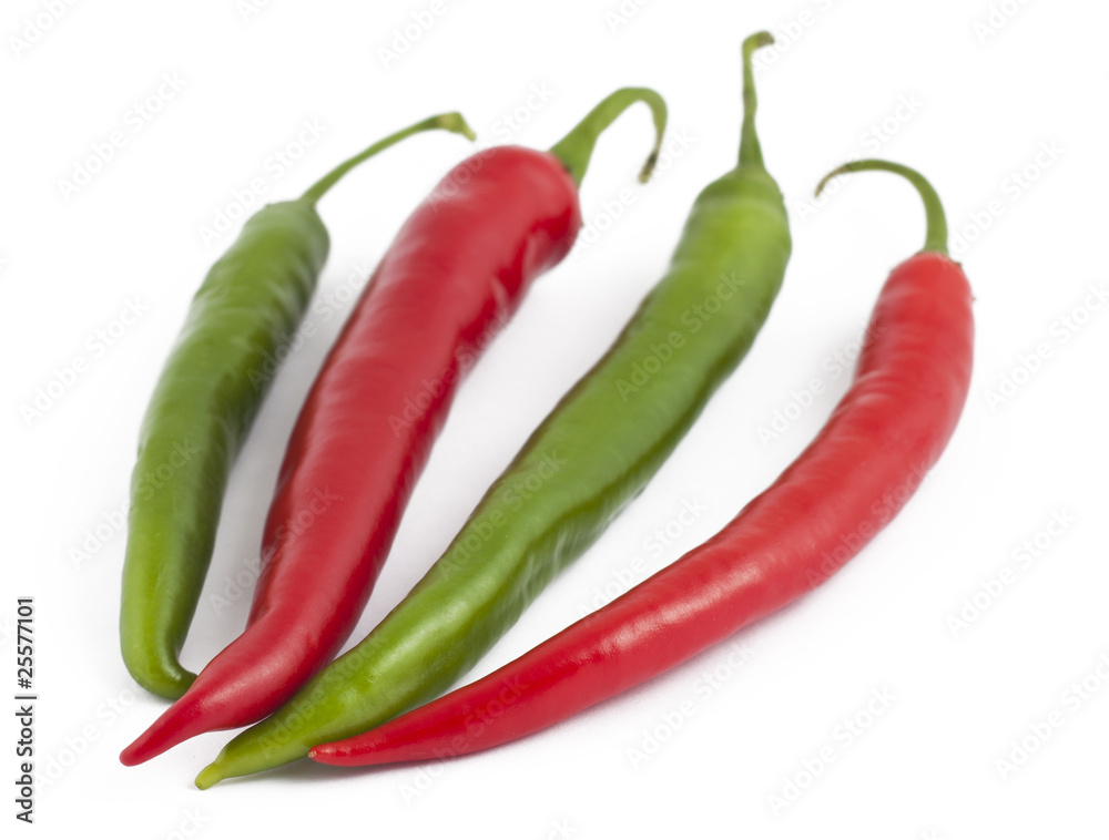 Two green and two red chili peppers on white