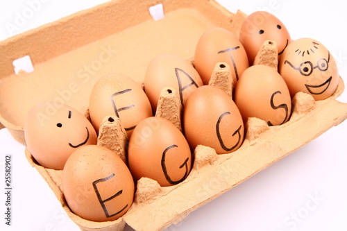 Eggs with an inscription EAT EGGS and with faces in a carton