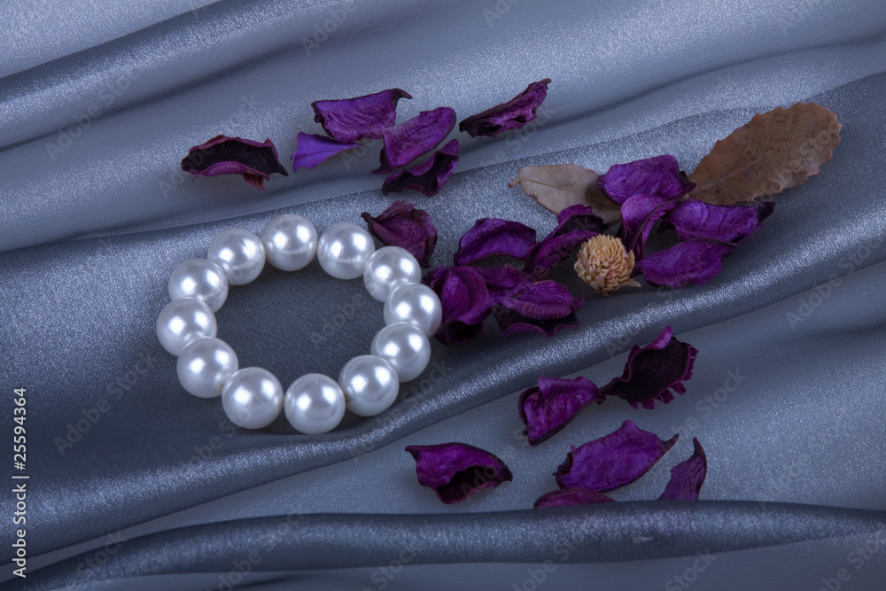 Obraz premium Жемчужный браслет и саше на фоне серебряной органзы