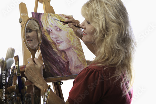 Valokuva blond female artist in her fifties painting self portrait