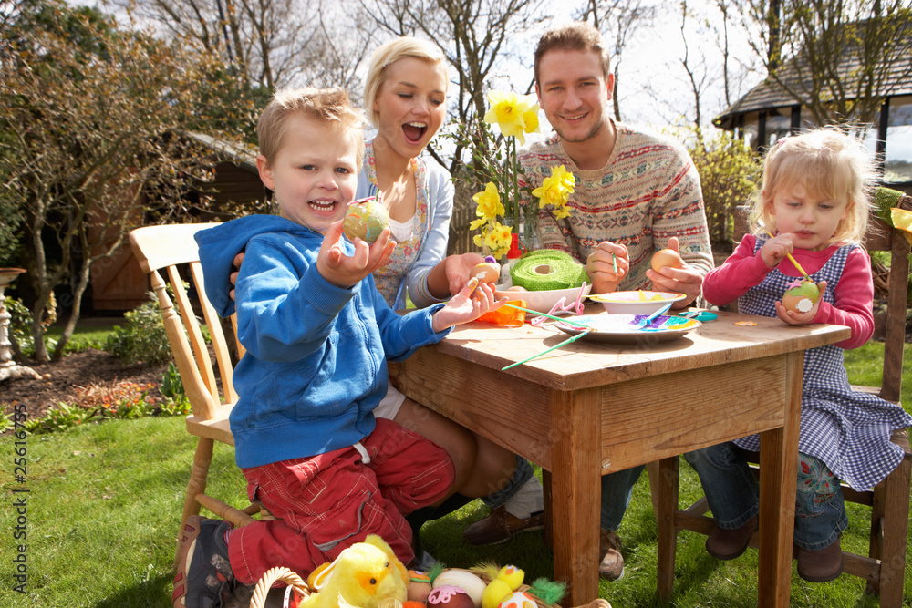 Obraz premium Family Decorating Easter Eggs On Table Outdoors