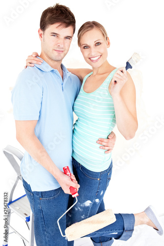 Loving caucasian couple painting a room photo